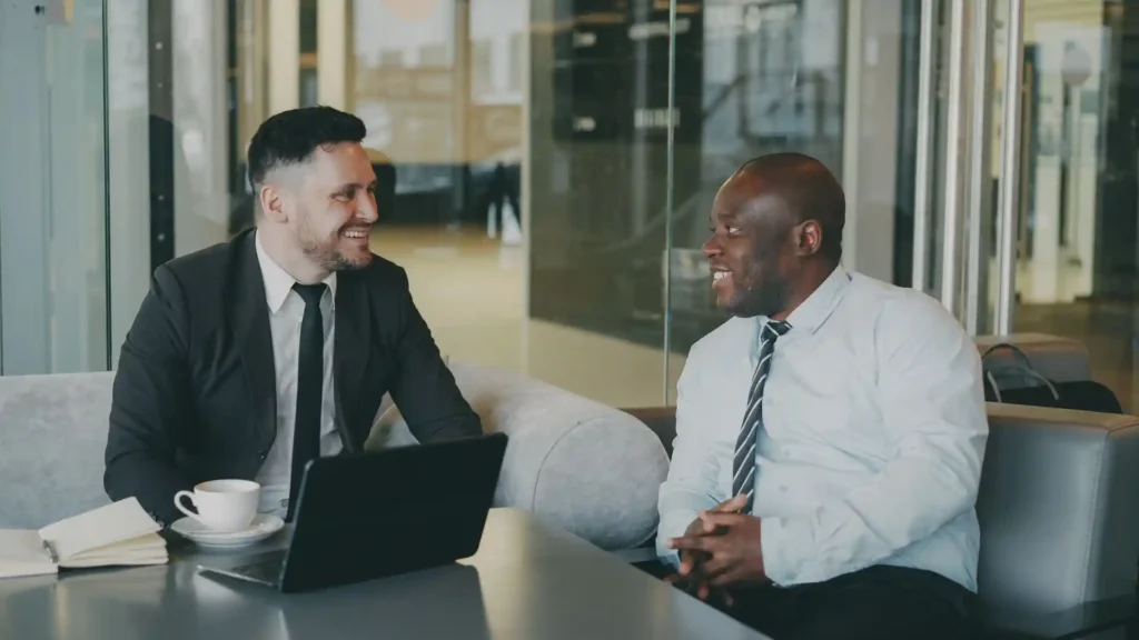 Two businessmen engaged in a professional meeting in a cafe.